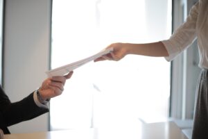 Photo of someone passing a documents to another person